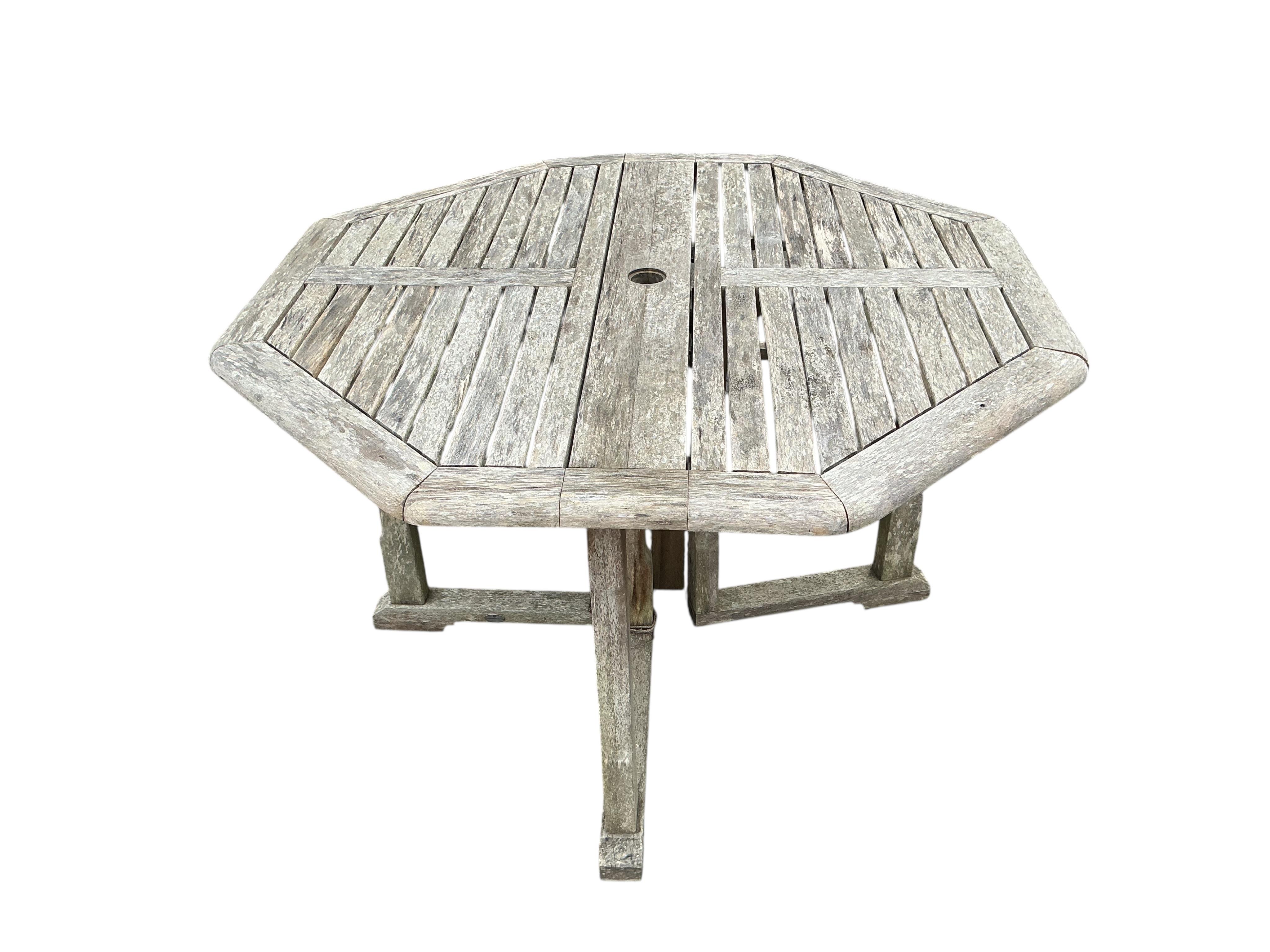 A weathered teak octagonal folding garden table, width 120cm, height 74cm